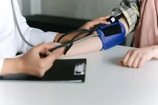 A healthcare worker uses a sphygmomanometer to show how to check blood pressure in a medical office.
