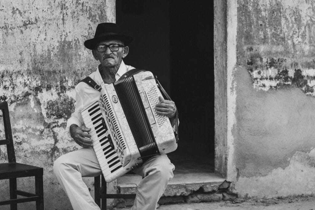 A senior man playing music outside a building